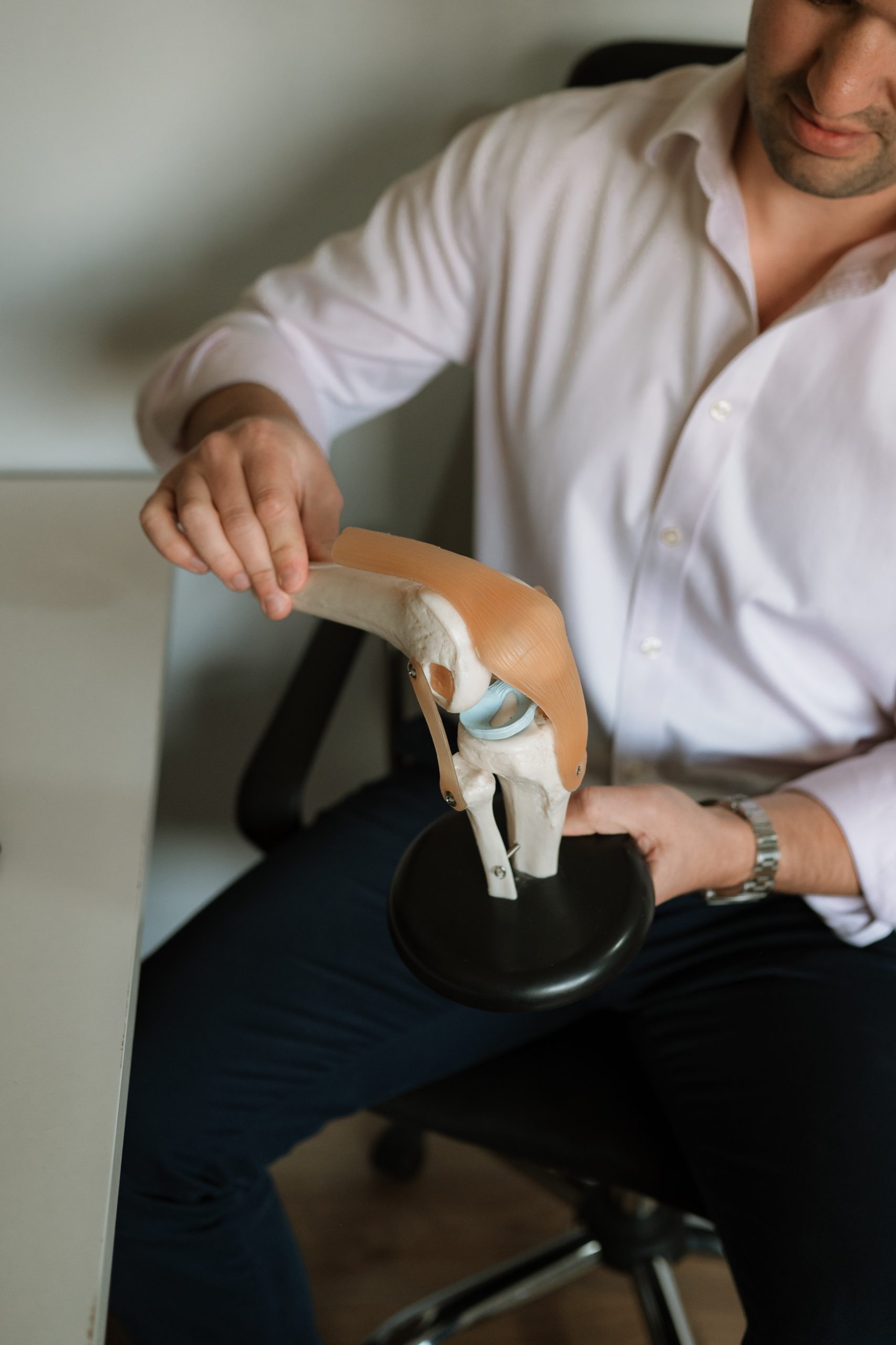 Rob demonstrating a knee model, explaining joint function and treatment approaches to patients